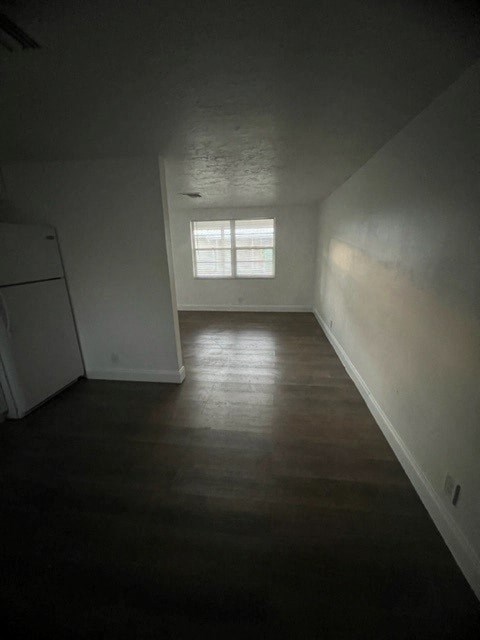 a white room with a refrigerator and a window