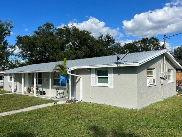 a white house with a metal roof and a grass yard