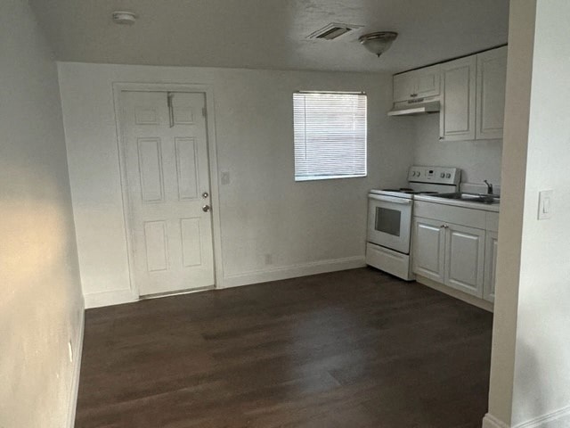 an empty kitchen with a stove and a door