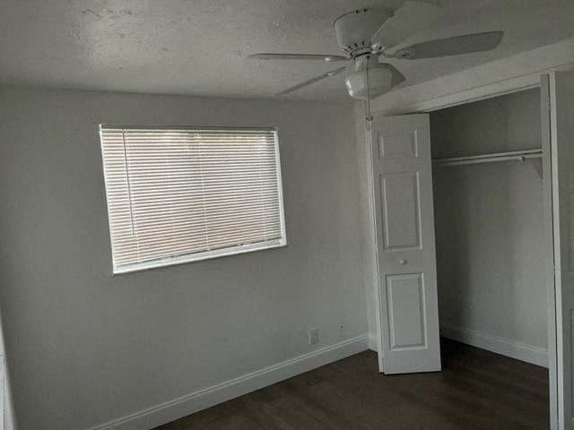 a room with a ceiling fan and a window and a closet