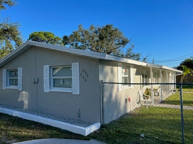 a small gray house with a fence and a yard