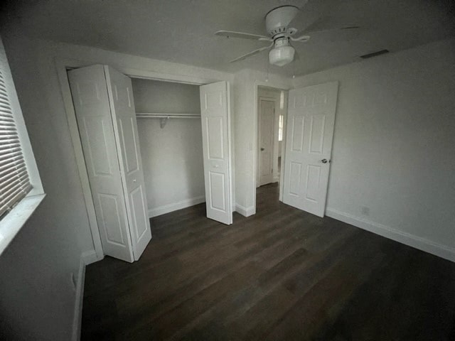a empty room with a ceiling fan and white doors