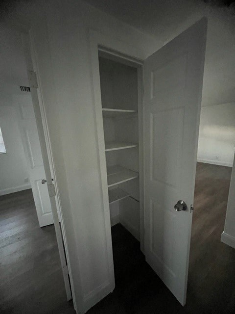 a small closet with shelves and a door
