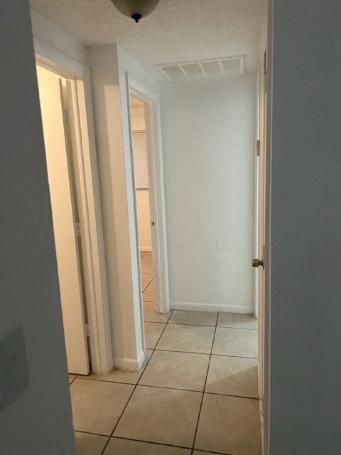 a hallway with a tiled floor and several doors