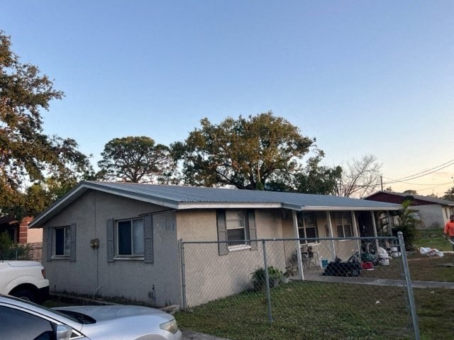 a house with a fence and cars parked in front of it