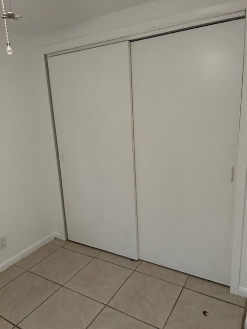 a room with two white closet doors and a tiled floor