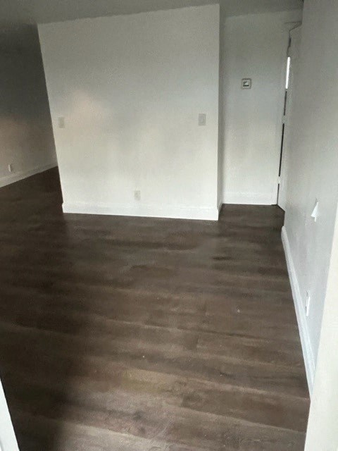 a living room with white walls and a wooden floor