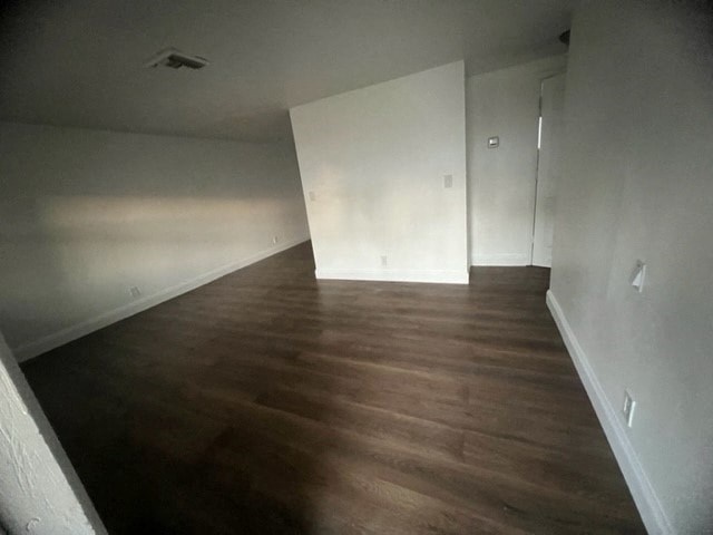 a empty room with a wood floor and white walls