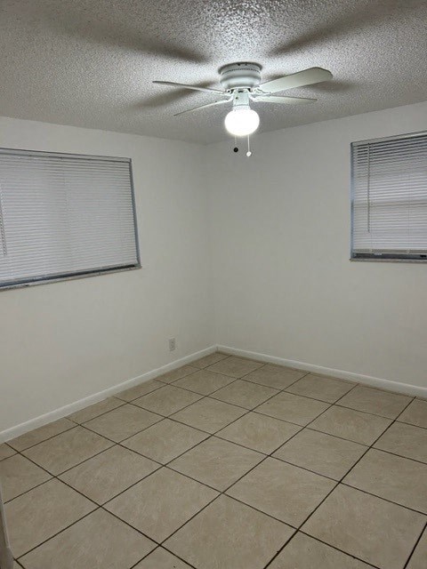 an empty room with a ceiling fan and a window