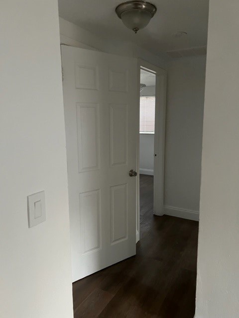 A hallway with a white door and a light on the ceiling.