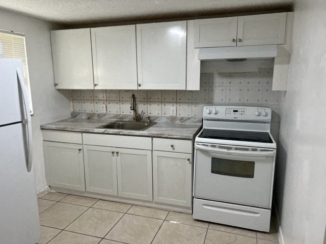 a white kitchen with a stove and a sink