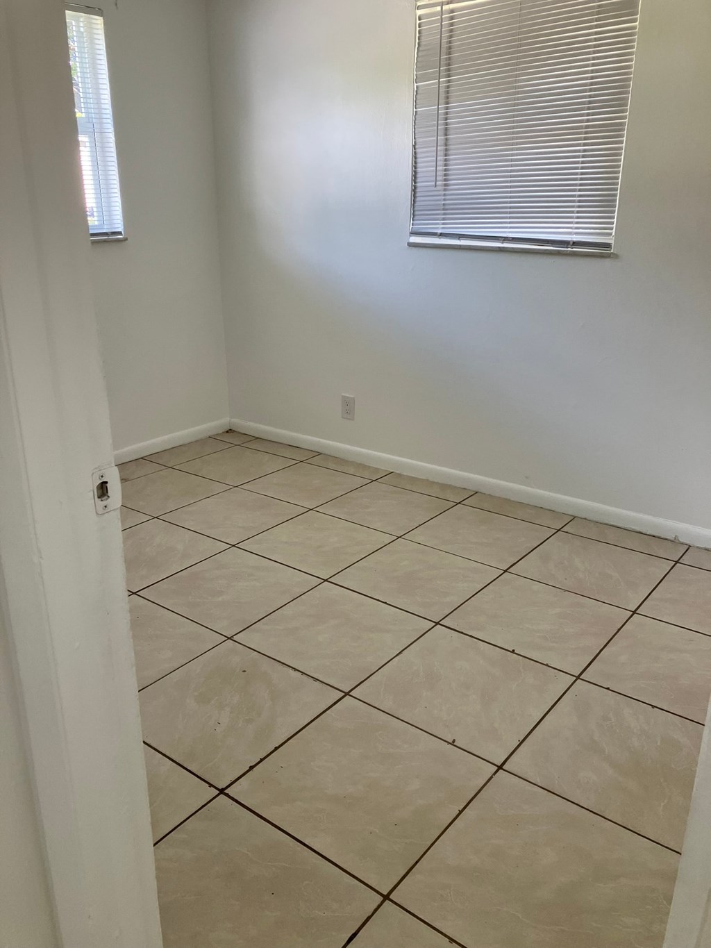 an empty room with a tiled floor and a window