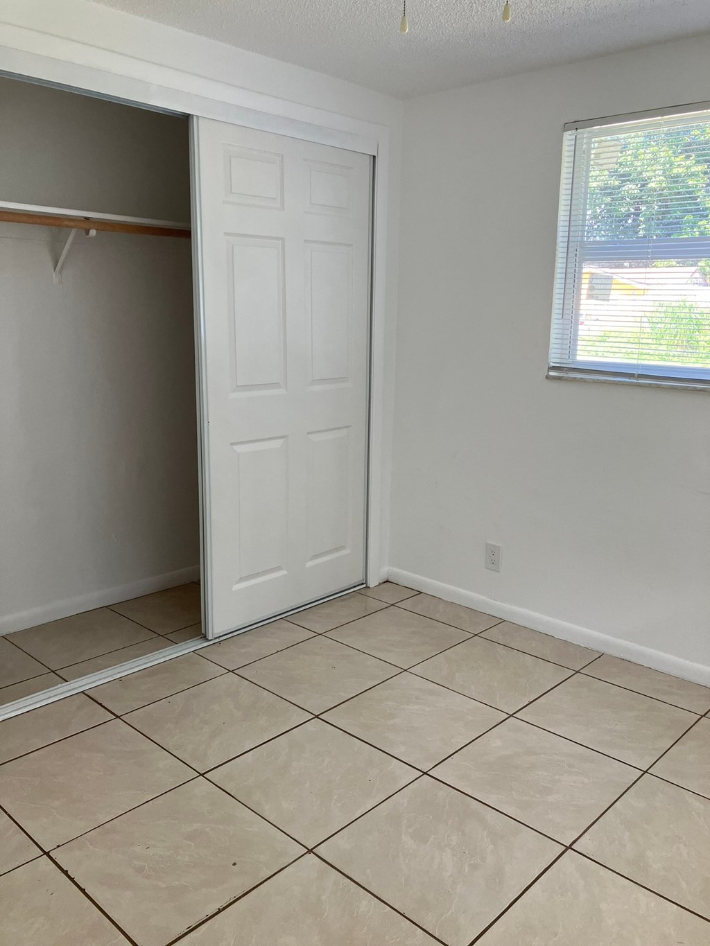 an empty room with a closet and a tiled floor