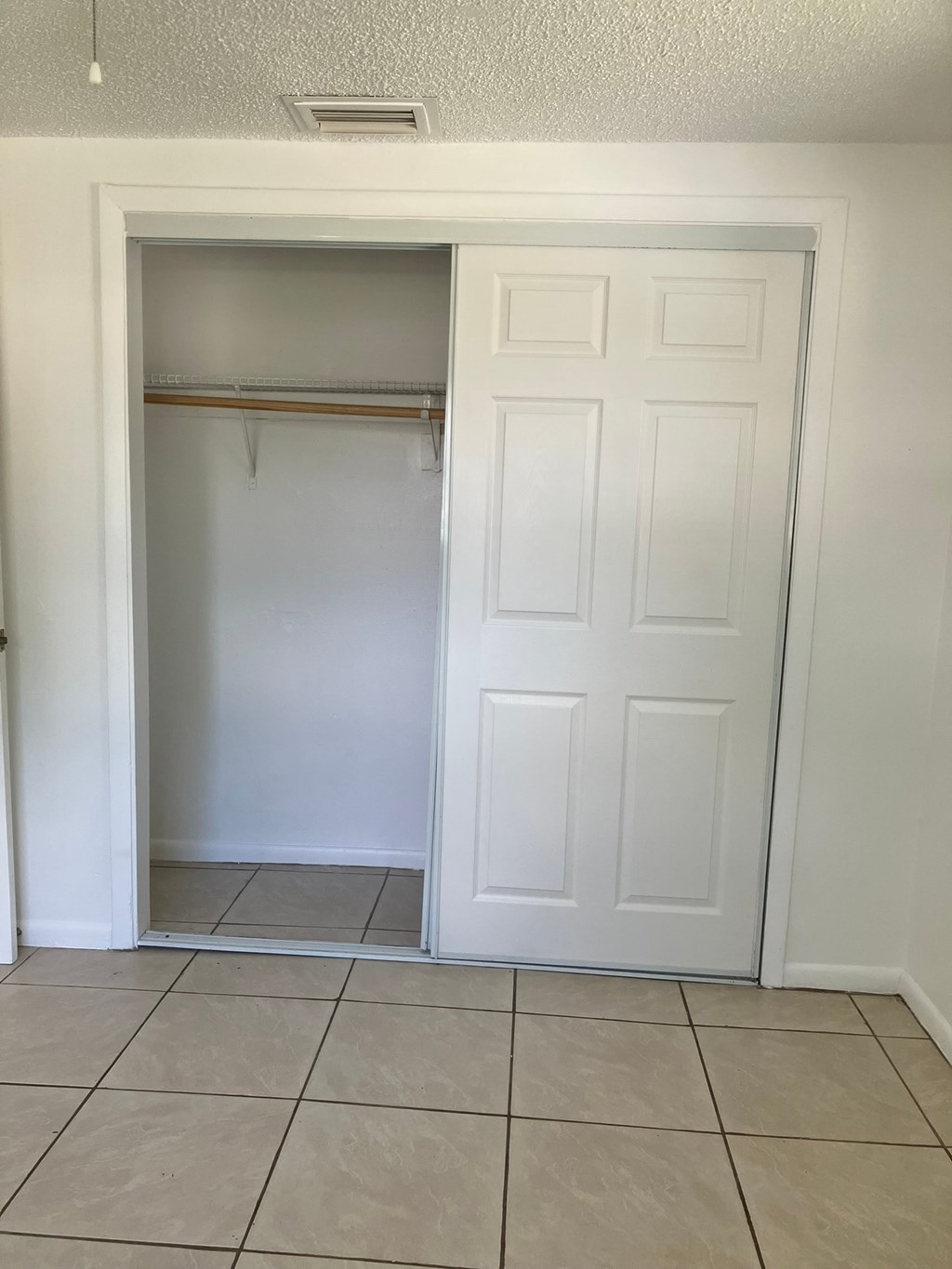 an empty closet in an empty room with a tiled floor