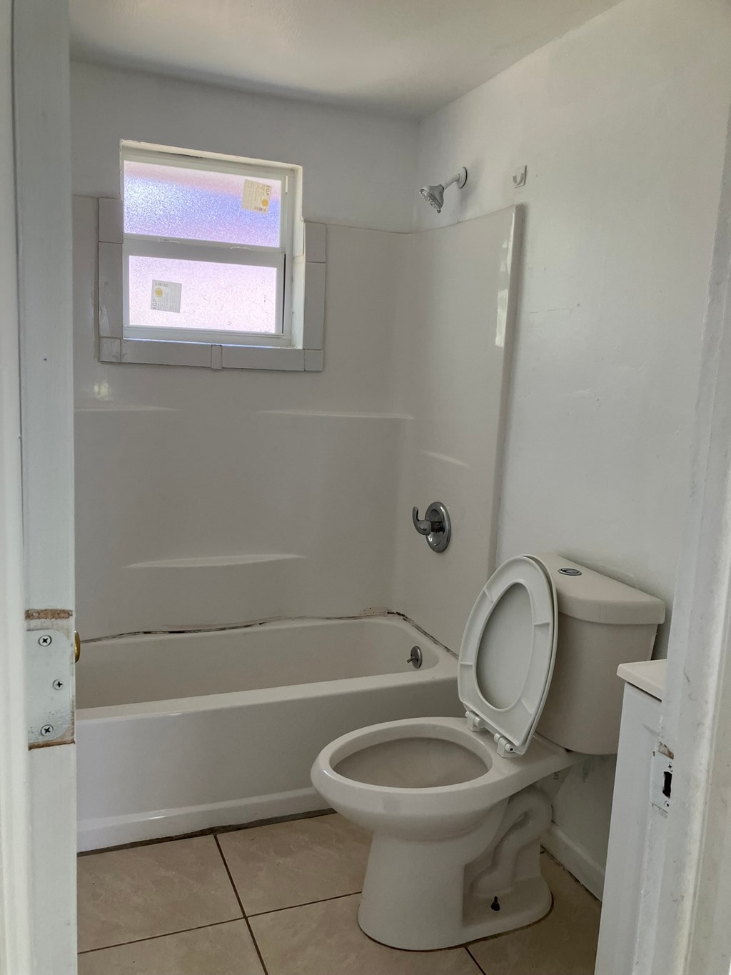 a bathroom with a toilet and a tub and a window
