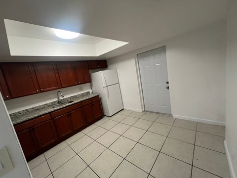 A kitchen with white appliances and brown cabinets.