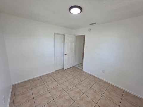 A room with a tiled floor and two doors.