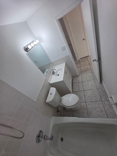 A white bathroom with a toilet, sink, and shower.