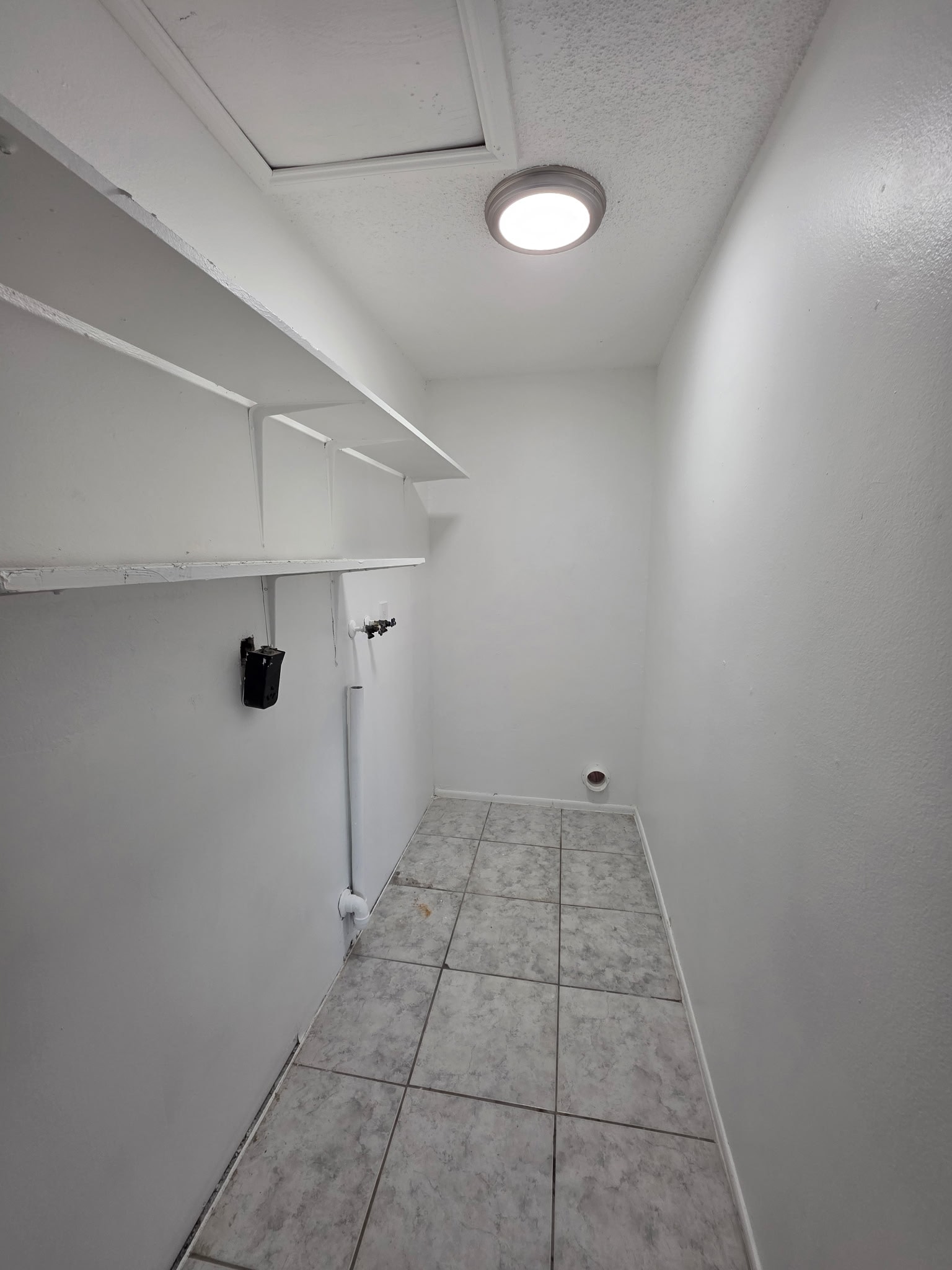 A white hallway with a light on the ceiling.
