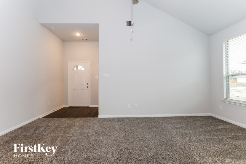 a living room with a carpeted floor and a white door
