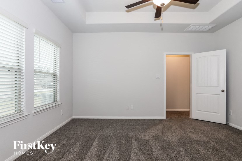 a living room with carpet and a ceiling fan