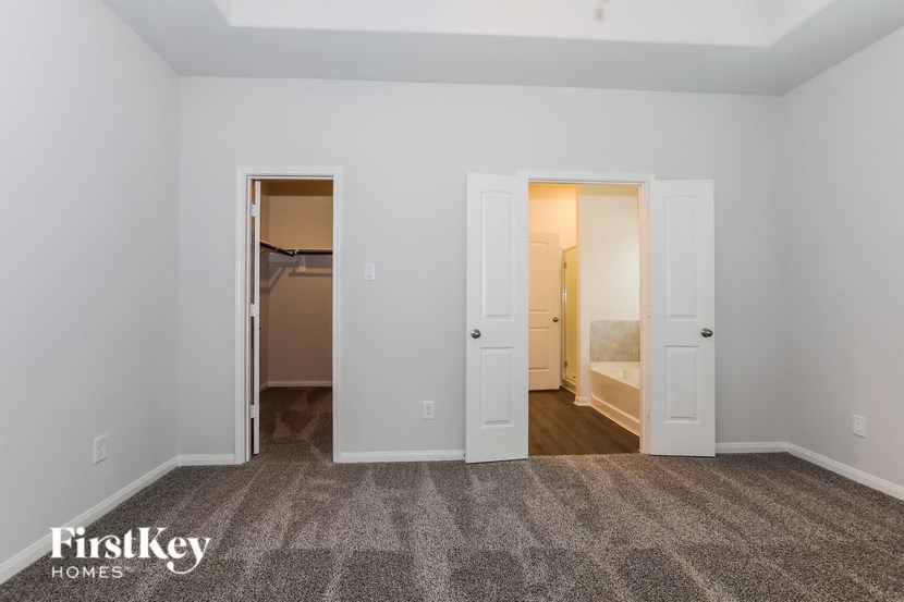 the living room of an apartment with white walls and a carpeted floor