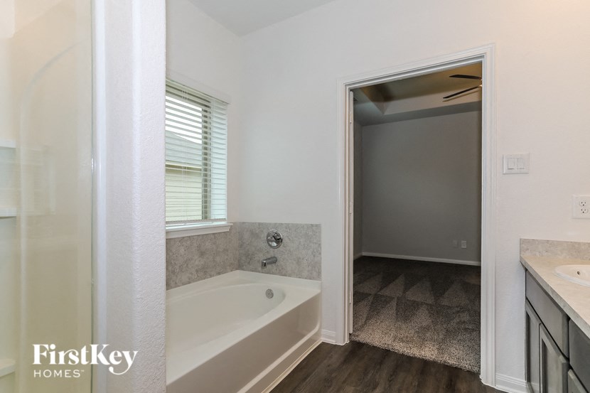 a bathroom with a tub and a sink and a mirror
