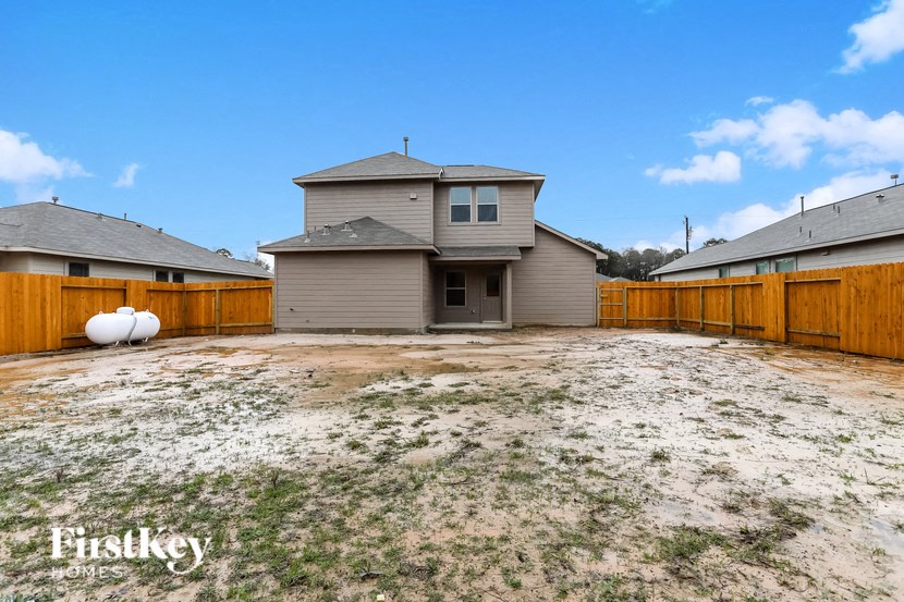 a backyard with a house and a wooden fence