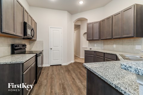 a renovated kitchen with granite counter tops and stainless steel appliances