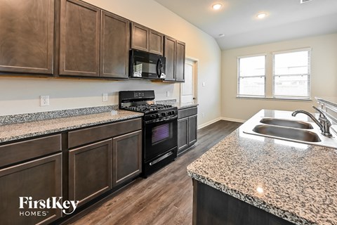 A kitchen with brown cabinets and a granite countertop.