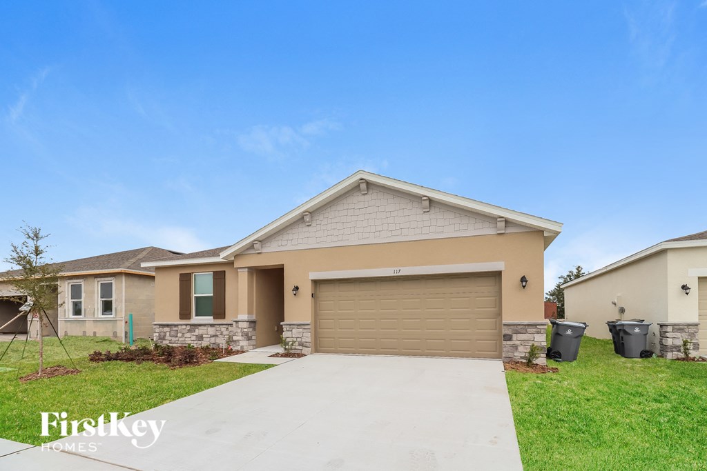 a beige house with a driveway and a garage door