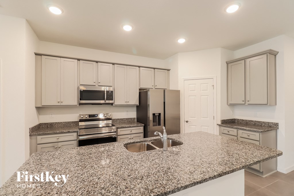 a kitchen with granite counter tops and white cabinets