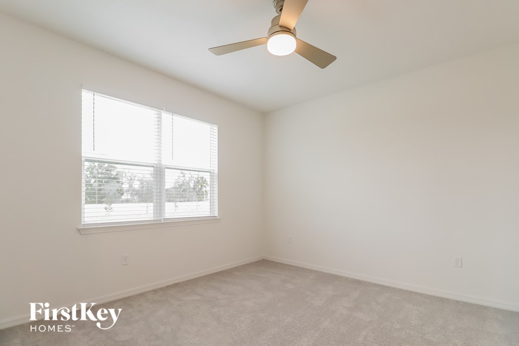 a bedroom with a ceiling fan and a window