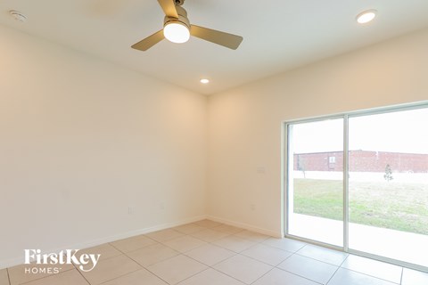 a living room with a ceiling fan and a large window