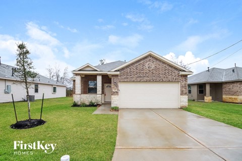 a brick house with a white garage door and a lawn