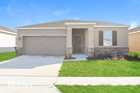 a beige house with a driveway and a garage door