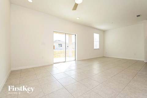 the spacious living room has tile flooring and sliding doors to the patio