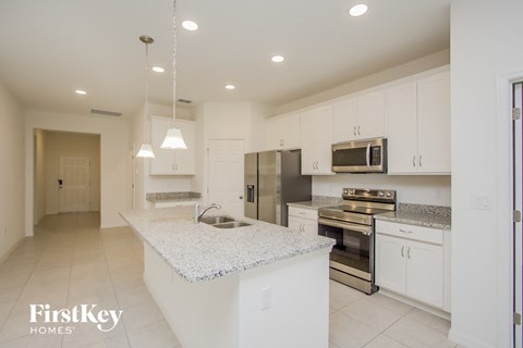 a kitchen with white cabinets and a marble counter top