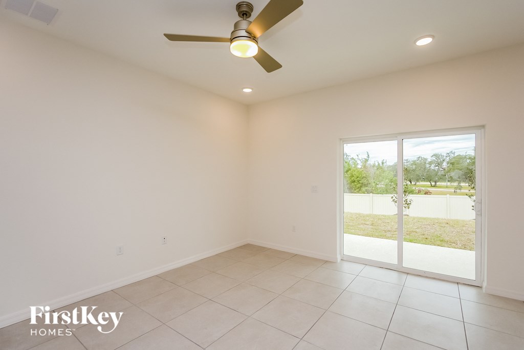 a living room with a ceiling fan and a tiled floor