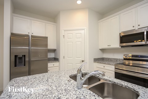 a kitchen with granite counter tops and stainless steel appliances
