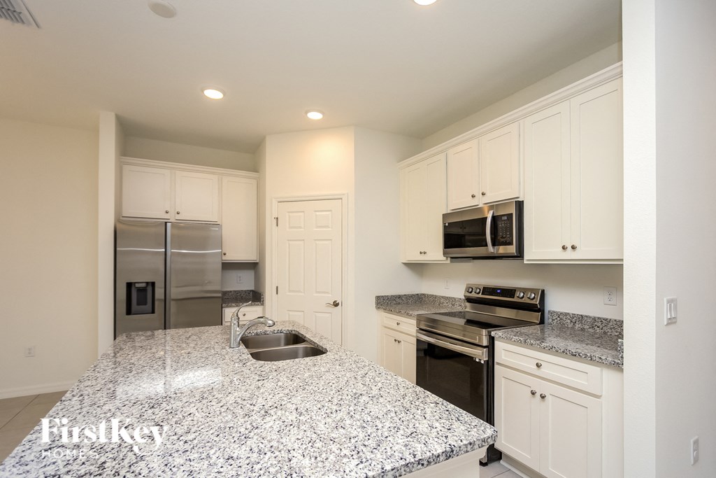 a kitchen with granite counter tops and stainless steel appliances