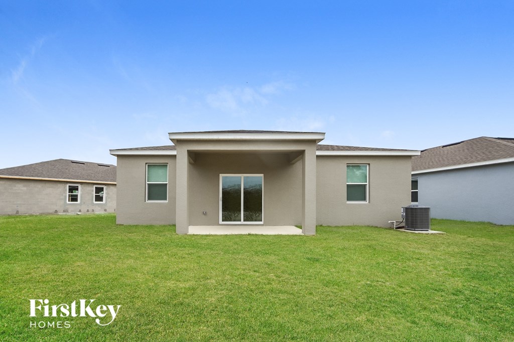 a beige house with a lawn and a blue sky