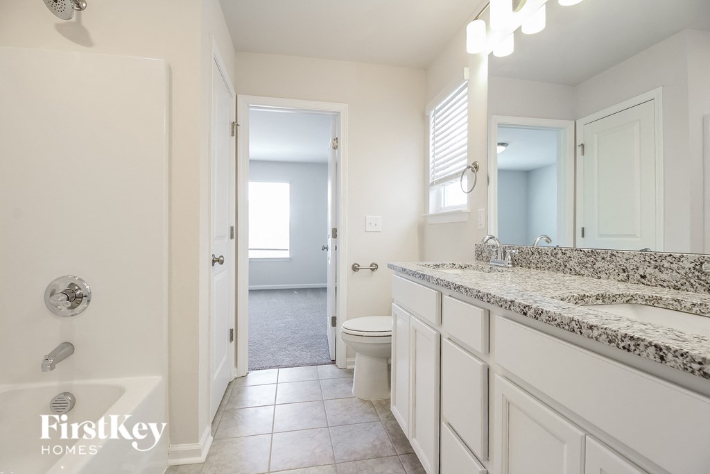 A bathroom with a marble countertop and a walk-in shower.