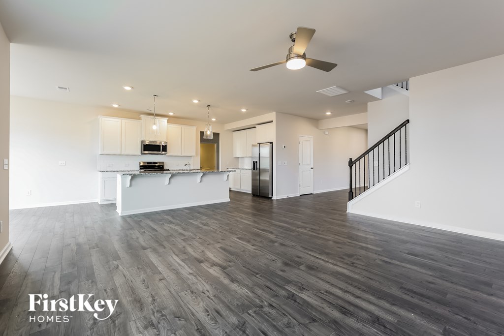 A spacious living room with a staircase on the right side.