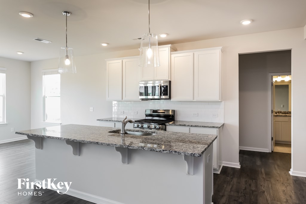A kitchen with a granite countertop and a stove top oven.