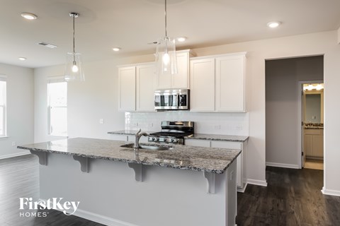 A kitchen with a granite countertop and a stove top oven.