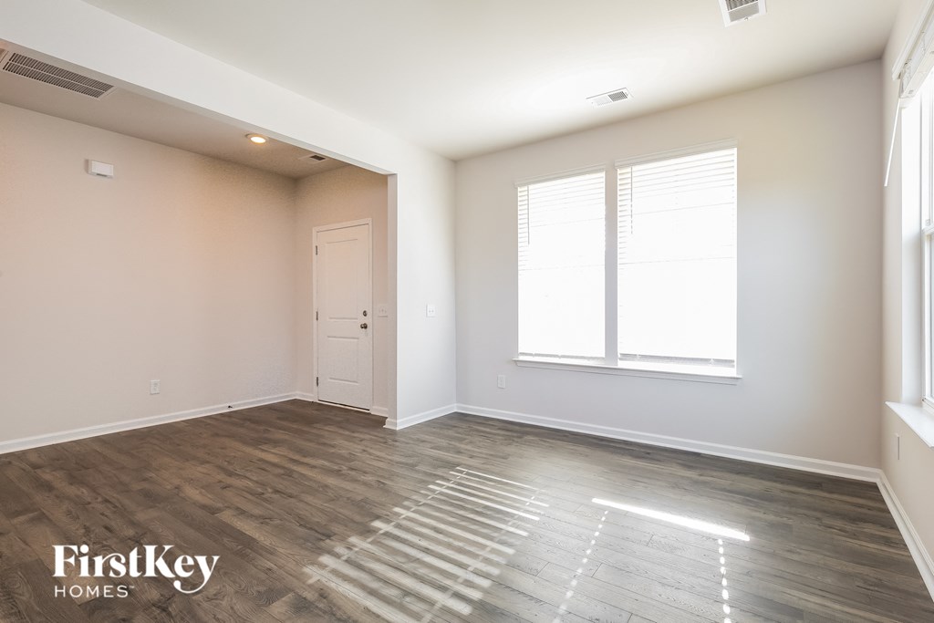 A room with wooden flooring and a white door.