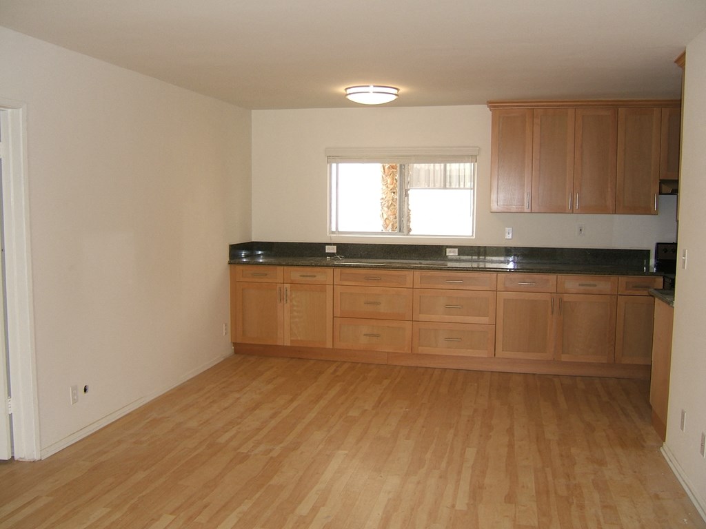 A kitchen with wooden floors and cabinets.
