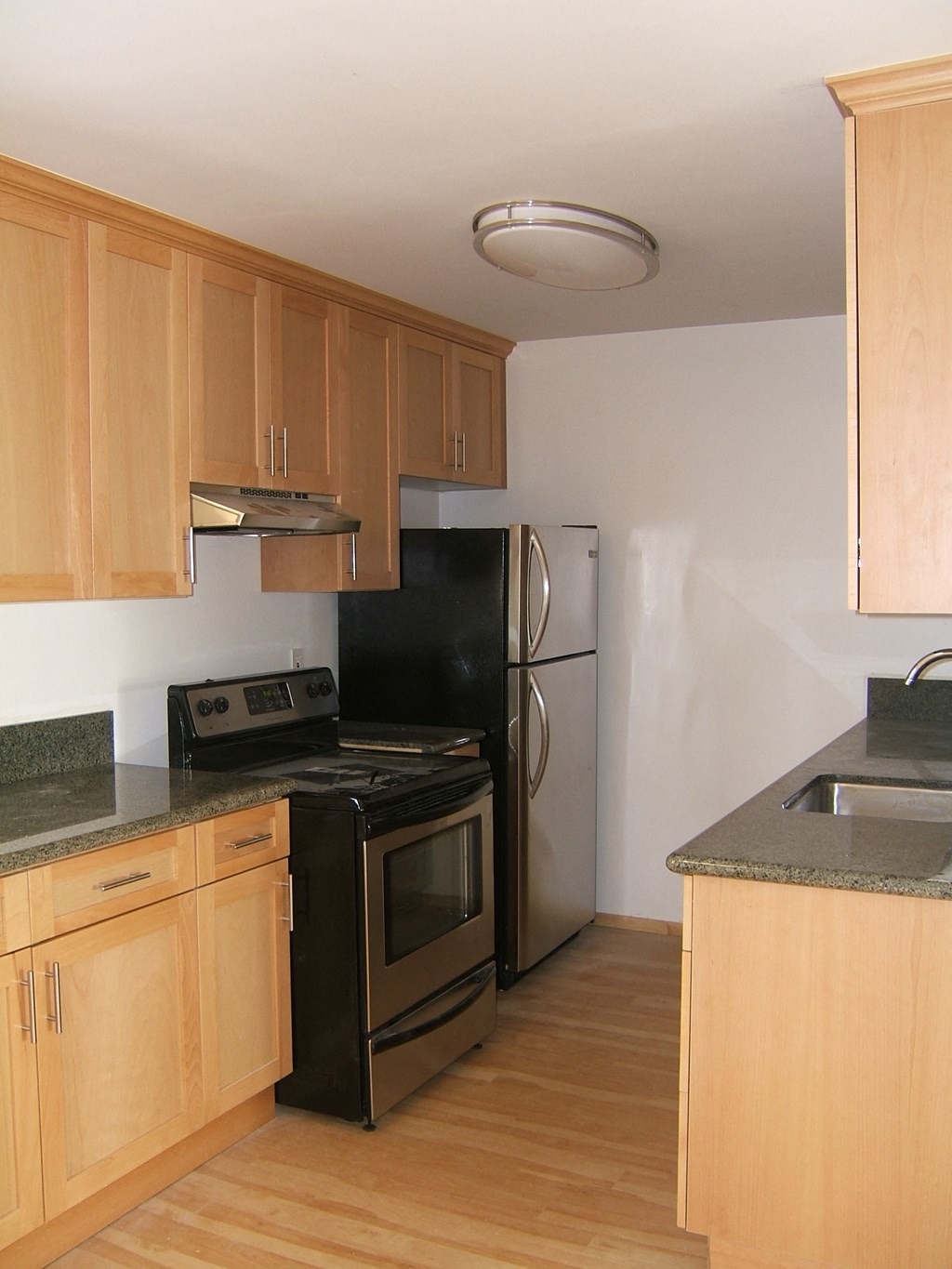 A kitchen with wooden cabinets and a black stove top oven.
