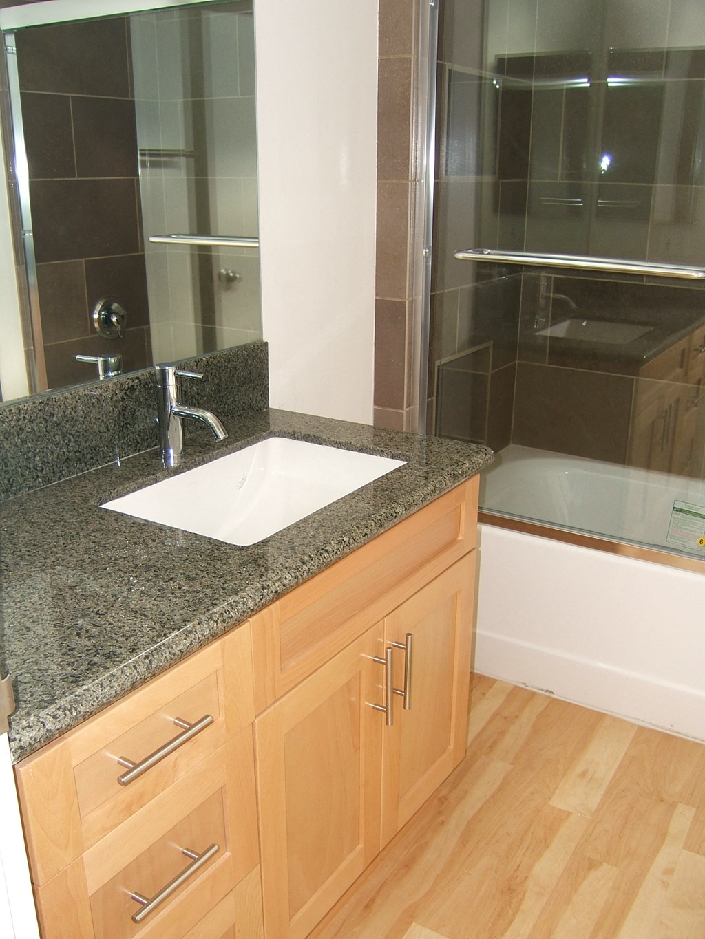 A bathroom with a sink and wooden cabinets.
